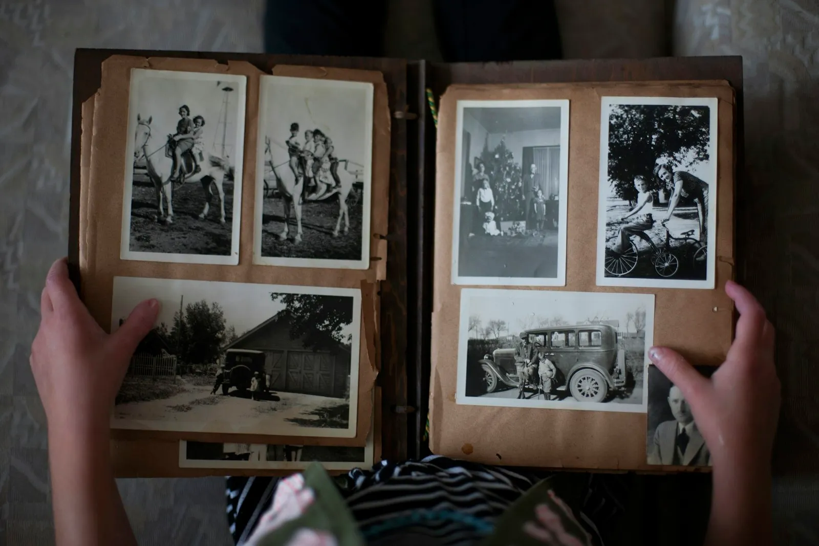 Hände blättern in einem alten Fotoalbum mit Schwarz-Weiß-Fotos der Familie